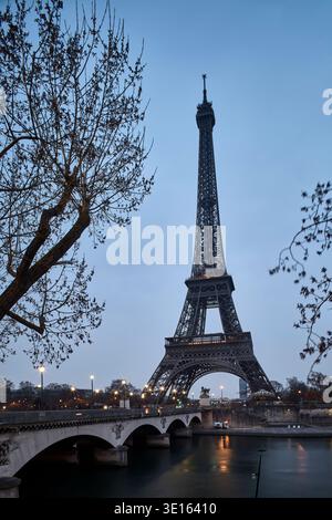 Torre Eiffel vista dal fiume sotto la luce blu della sera. Foto Stock