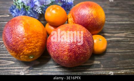Agrumi freschi, arance rosse e mandarini su una tavola di legno - un concetto di sana alimentazione. Foto Stock