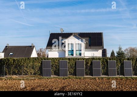 Casa moderna con pannelli solari sul tetto e moduli fotovoltaici installati in una zona residenziale in Germania Foto Stock