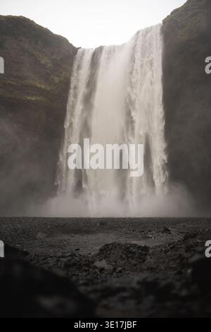 La bellezza mozzafiato della cascata Skogafoss in Islanda durante l'inverno. L'acqua a cascata, circondata da aspre scogliere, crea una natura maestosa Foto Stock