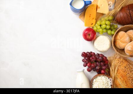 Festeggiate Shavuot con un delizioso spettacolo con prodotti lattiero-caseari assortiti, frutta fresca e una varietà di pane. Perfetto per una festa e una prelibatezza Foto Stock