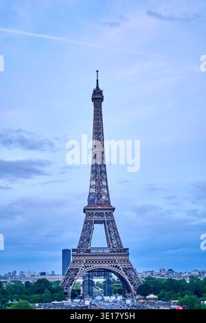 La Torre Eiffel si erge maestosamente contro un cielo blu morbido con nuvole sparse, catturate durante le ore di luce del giorno a Parigi, in Francia. Il... Foto Stock