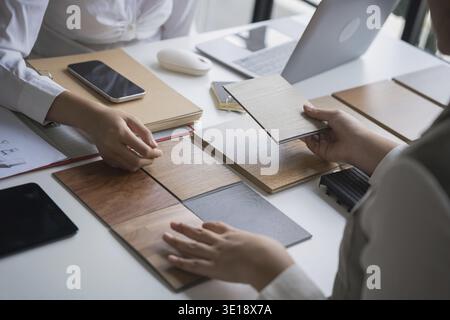 Designer di interni che presenta campioni di materiali in legno ecocompatibili per un arredamento sostenibile Foto Stock