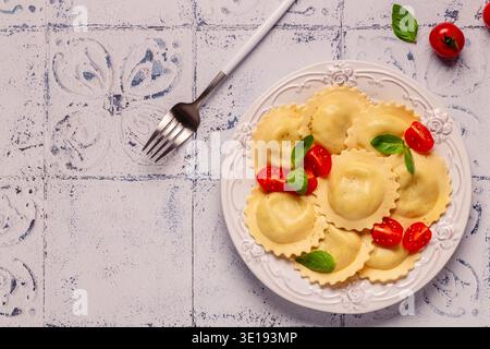 Ravioli con salsa di pomodoro e basilico su piatto bianco. Foto Stock