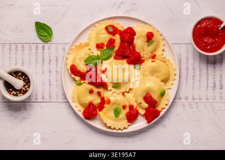Ravioli con salsa di pomodoro e basilico su piatto bianco. Foto Stock