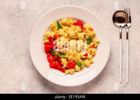 Pasta ripiena italiana. Sacсhettini pasta in un piatto con salsa di pomodoro. Foto Stock
