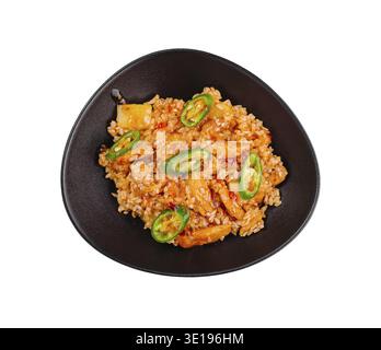 Il pollo agrodolce con riso e ananas viene servito su un piatto nero, guarnito con peperoncino Foto Stock