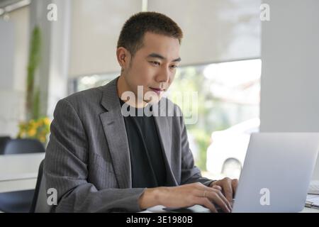 Uomo d'affari che lavora utilizzando il computer portatile e le mani digitando la tastiera. Investitore professionale che lavora per il progetto Start-up. pianificazione aziendale in ufficio. Tecnol Foto Stock