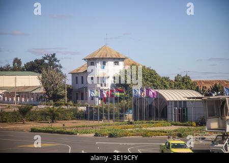 Antananarivo, Madagascar - 5 ottobre 2023: Struttura storica con bandiere esposte in aeroporto immersa nel verde Foto Stock