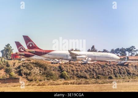 Antananarivo, Madagascar - 5 ottobre 2023: Aereo Madagascar parcheggiato in collina con design a coda rossa e alberi verdi sullo sfondo Foto Stock