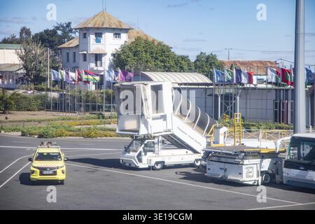 Antananarivo, Madagascar - 5 ottobre 2023: Scena aeroportuale con scale d'imbarco e bandiere con edificio del terminal sullo sfondo Foto Stock
