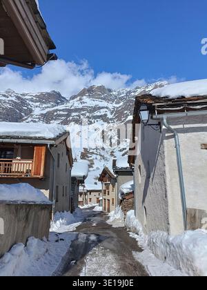 Strada alpina con neve e montagne a Bessans, Alpi francesi Foto Stock