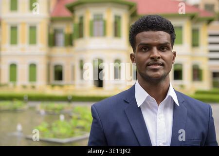 Ritratto di bell'uomo d'affari africano all'aperto con vestito Foto Stock