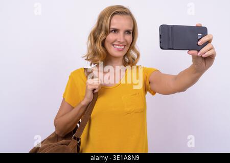 Foto in studio di una bella donna turistica bionda su sfondo bianco Foto Stock
