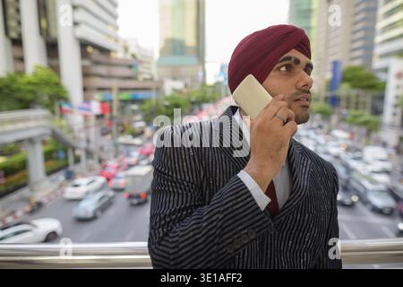 Ritratto di giovane bello indiano imprenditore Sikh indossando turbante mentre esplorate la città di Bangkok, Thailandia Foto Stock