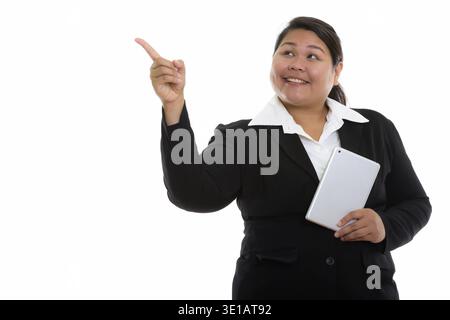 Riflessivo giovani felici fat Asian imprenditrice sorridente tenendo tavoletta digitale e puntare il dito fino Foto Stock