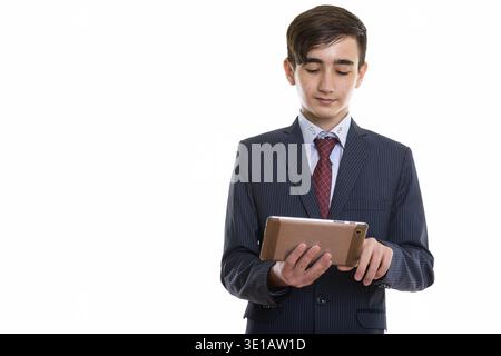 Studio girato di giovane bel ragazzo persiano uomo d'affari adolescente utilizzando il digitale tablet Foto Stock