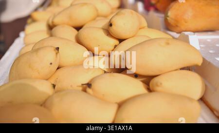 Mango e papaya freschi aspettano i clienti presso uno stand di frutta in India Foto Stock