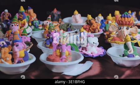 Creazione artigianale di idoli colorati di Ganesha in argilla per la celebrazione del festival Ganesh Chaturthi Foto Stock