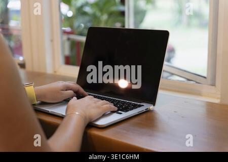 Donna asiatica che utilizza computer portatile ragazza creativa che lavora e digita sulla tastiera Foto Stock