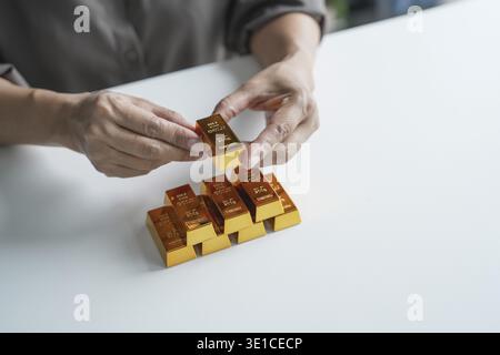 Anziana donna asiatica anziana che commercializza investimenti in risparmio d'oro per il reddito pensionistico e il profitto Golden Futures. donna d'affari degli anni '60 Foto Stock