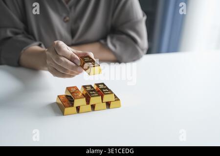 Anziana donna asiatica anziana che commercializza investimenti in risparmio d'oro per il reddito pensionistico e il profitto Golden Futures. donna d'affari degli anni '60 Foto Stock