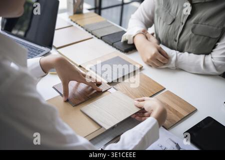 Designer di interni che presenta campioni di materiali in legno ecocompatibili per un arredamento sostenibile Foto Stock