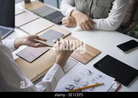 Designer di interni che presenta campioni di materiali in legno ecocompatibili per un arredamento sostenibile Foto Stock