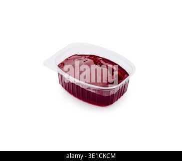 La gelatina rossa brillante si trova in un contenitore di plastica trasparente, pronto per essere gustato a una festa o a una riunione di famiglia. La consistenza liscia invita a un'esperienza dolce Foto Stock