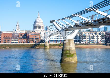 I visitatori passeggiano attraverso il Millennium Bridge, godendosi una giornata di sole sul Tamigi. La Cattedrale di San Paolo si erge maestosamente sullo sfondo, mostrando la sua iconica cupola. Foto Stock