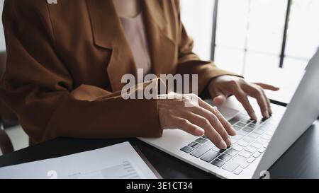 Maturo business asiatico donna imprenditrice in ufficio che utilizza laptop. donna d'affari degli anni '60 con donna anziana asiatica di tecnologia Foto Stock