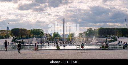Parigi, Francia - 08 04 2025: Ampia vista panoramica dal Giardino delle Tuileries verso Place de la Concorde. L'immagine mostra i visitatori seduti in classe Foto Stock