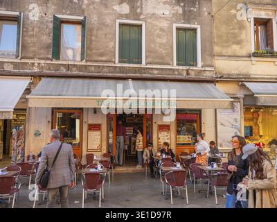 Venezia, Italia. 28.10.2022 non è il luogo turistico più popolare di Venezia. periferia della città. canali, case e ponti. piccolo caffè con alcuni tavoli Foto Stock