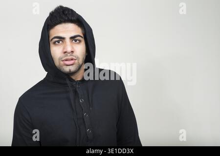 Foto in studio di un giovane e bell'uomo indiano barbuto su sfondo bianco Foto Stock