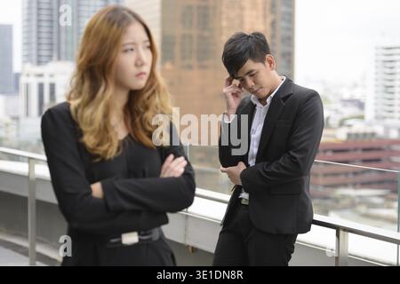 Ritratto di un giovane uomo d'affari asiatico e di una giovane donna d'affari asiatica insieme in città all'aperto Foto Stock