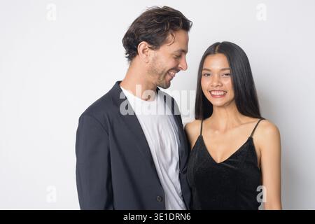 Foto in studio del bellissimo uomo d'affari ispanico e della giovane bella donna d'affari asiatica insieme su sfondo bianco Foto Stock