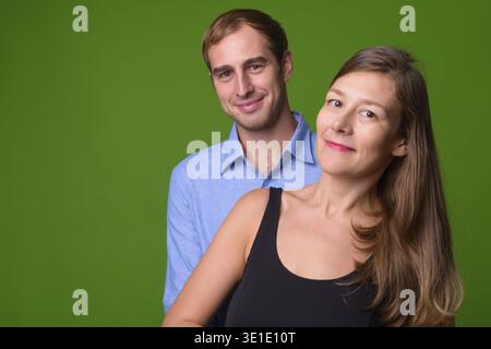 Foto in studio di giovani coppie insieme su sfondo verde Foto Stock