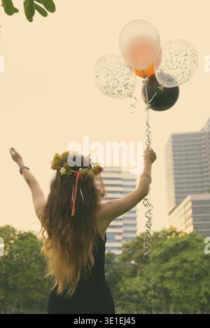 Ritratto di giovane donna bella celebrando la laurea presso il parco a Bangkok, in Thailandia Foto Stock