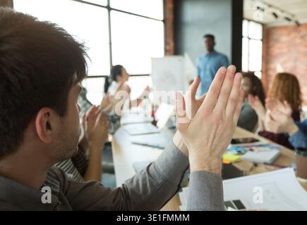 Uomini d'affari che battono le mani per parlare durante la riunione Foto Stock