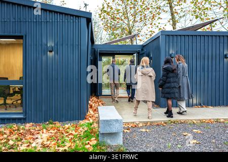 Professionisti che entrano in un moderno edificio per uffici di coworking realizzato con contenitori per spedizioni Foto Stock