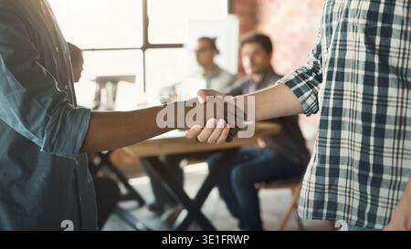 Stretta di mano tra l'uomo africano e quello caucasico all'incontro Foto Stock