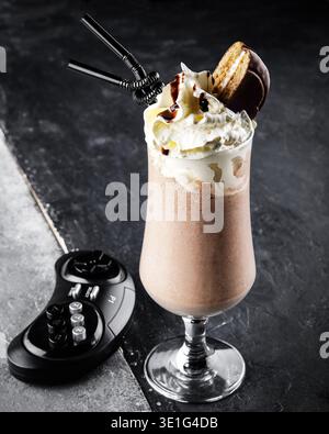 Cremoso Milkshake guarnito con panna montata e biscotti in stile nostalgico Diner Foto Stock