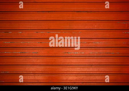 Design astratto con linee orizzontali in ferro vecchio ruggine. Primo piano sfondo rosso metallico della porta a rotelle. Sfondo otturatore in metallo. Modello di otturatore a rullo in acciaio. Foto Stock