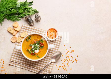 Pentola di gustosa zuppa di lenticchie e crostini su sfondo beige grunge Foto Stock