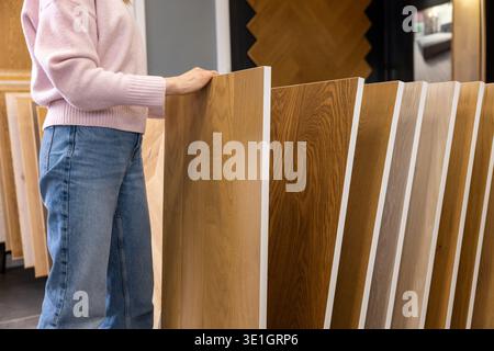 donna che sceglie mobili e materiali per pavimenti in studio di interior design Foto Stock