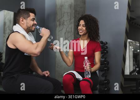 Una coppia di fitness si riposa e parla in palestra Foto Stock