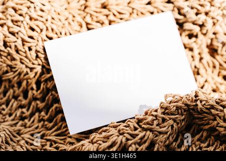 Biglietto da visita bianco vuoto su sfondo in tessuto naturale testurizzato. Mockup di branding minimalista con tonalità calde e spazio di copia per logo, identità o design Foto Stock