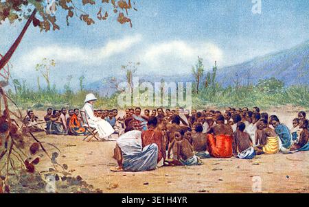 Una signora in bianco che insegna ai nativi del cristianesimo. La missione delle università in Africa centrale, risalente al 1910 circa. Una lezione di ascoltatori a Mangoche, Nyasaland. Gli ascoltatori erano coloro che desideravano saperne di più sul cristianesimo e che venivano regolarmente per l'istruzione. Quelli mostrati qui sono della tribù Yao. Da una cartolina originale. Foto Stock