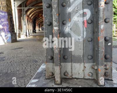 Primo piano del pilastro industriale in metallo sotto il ponte Oberbaum a Berlino. Foto Stock