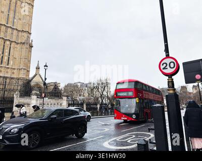 Londra, Regno Unito - 1° febbraio 2026: London Street immersa nella pioggia con l'iconico autobus rosso a due piani, pedoni, automobili e la storica architettura di Westminster. Foto Stock
